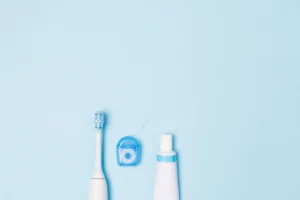 Essential dental hygiene tools including a toothbrush, floss, and toothpaste, recommended for brushing by Montana Center for Implants and Dentures.