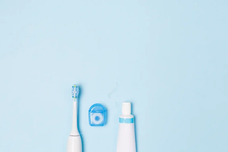 Essential dental hygiene tools including a toothbrush, floss, and toothpaste, recommended for brushing by Montana Center for Implants and Dentures.