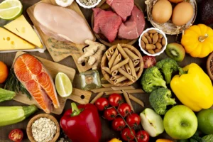 Assorted healthy foods including fruits, vegetables, lean meats, and whole grains that contribute to teeth health, as recommended by Montana Center for Implants and Dentures.