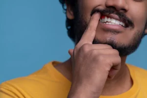 Close-up of an adult man showing signs of gum disease, a condition that can lead to the need for dental implants, treated at Montana Center for Implants and Dentures.