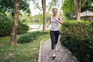 Young woman jogging in the park, emphasizing the importance of physical activity for heart health and oral health, promoted by Montana Center for Implants and Dentures.