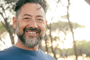 Happy man with a confident smile after a smile makeover from Montana Center for Implants and Dentures.