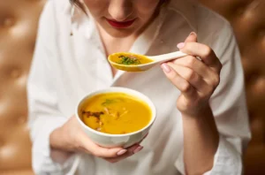 Person eating soft food after bone graft and oral surgery, recommended by Montana Center for Implants and Dentures