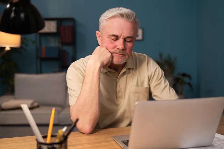 Elderly man researching options for relieving pain after dental implants online, exploring treatments from Montana Center for Implants and Dentures