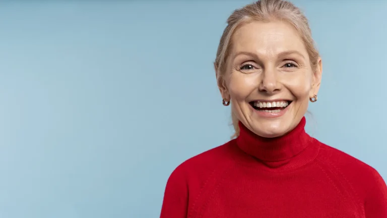 Happy senior woman showcasing her bright smile after a smile makeover with natural-looking dentures from Montana Center for Implants and Dentures.
