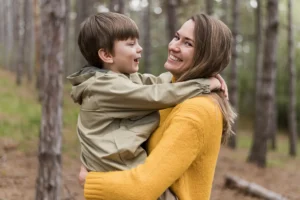 A joyful mother and son sharing a moment outdoors, showcasing restored smiles in Montana after a smile makeover at Montana Center for Implants and Dentures.