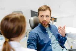 Male patient discussing sinus graft procedure and dental implants with a dentist at Montana Center for Implants and Dentures to improve oral health.