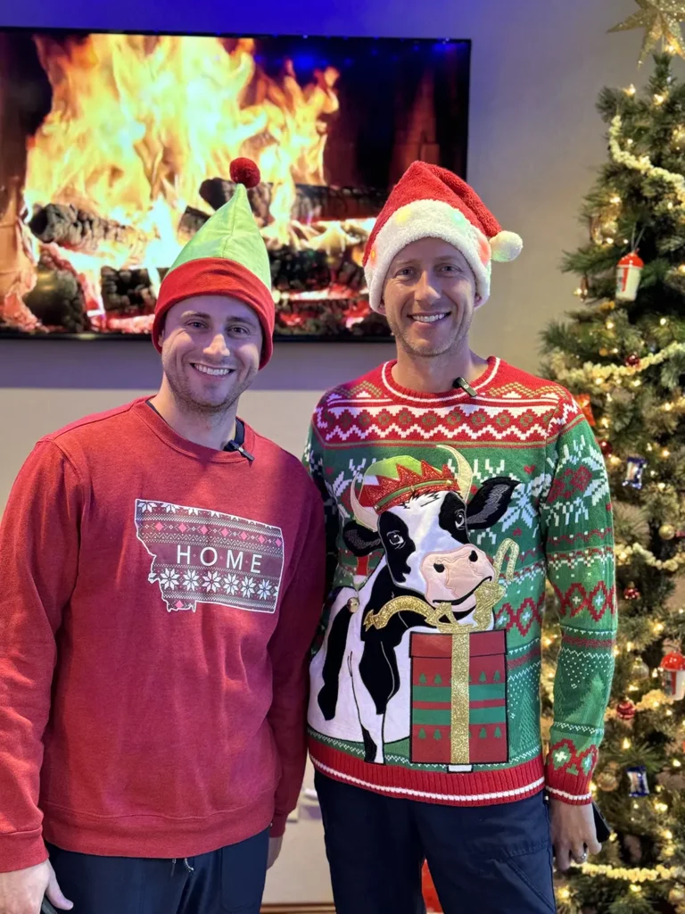 Dr. Josh Muir and Dr. Tanner Townsend with Montana Center for Implants and Dentures dressed for Christmas in ugly sweaters and santa hats